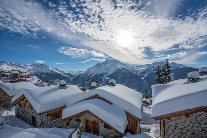 Snowy chalets in foreground of ski mountain