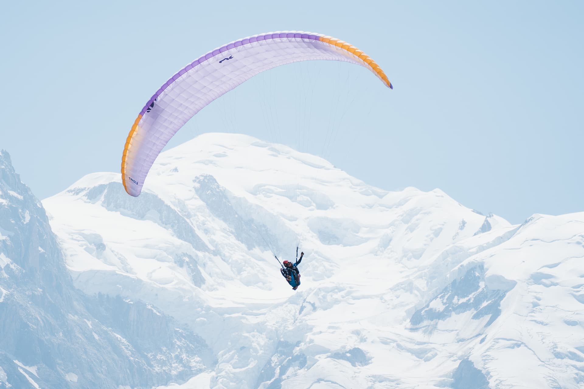 Winter tandem paragliding over snowy mountains in winter